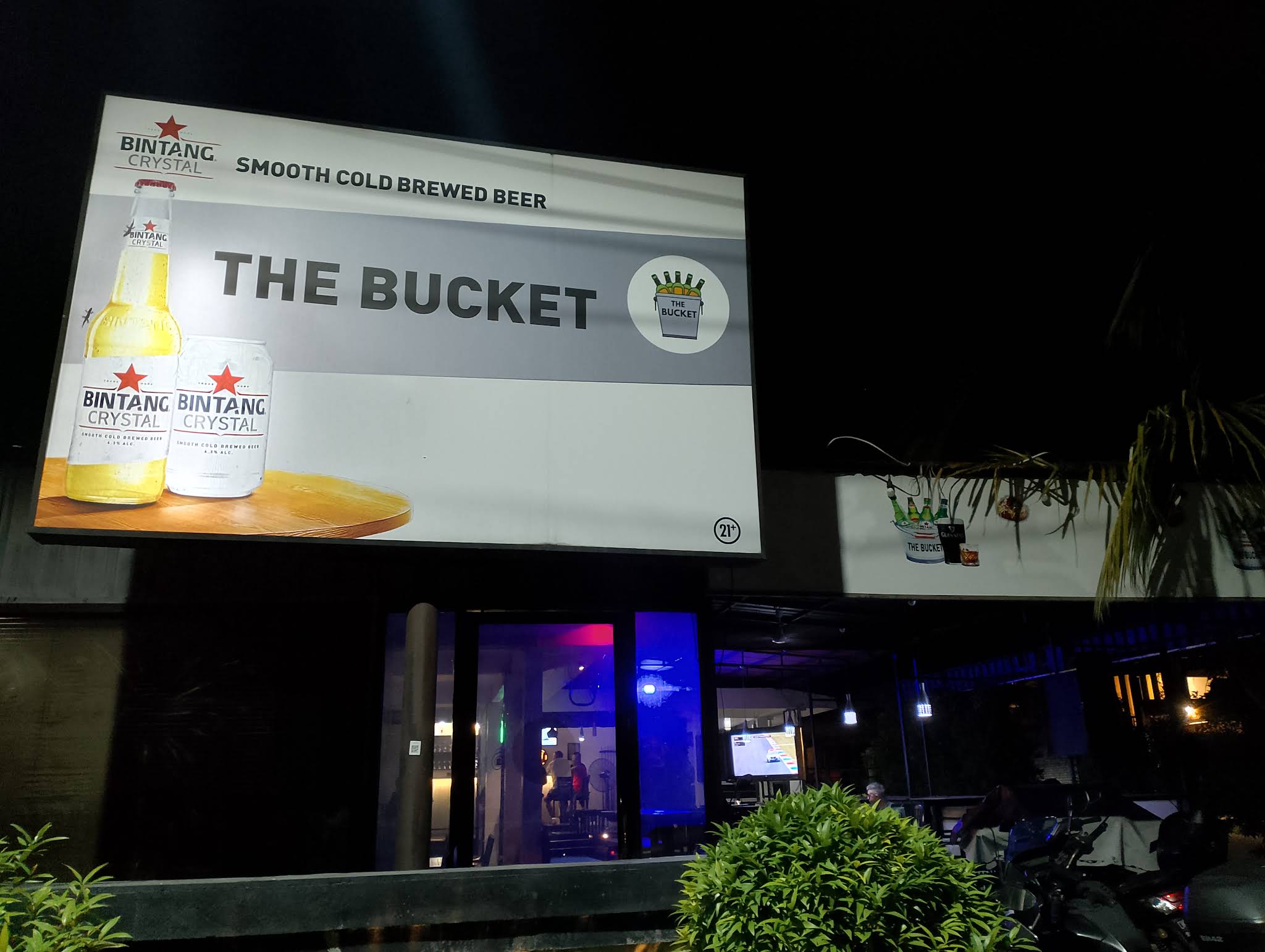 The Bucket Jimbaran entrance and blue-lit bar after dark