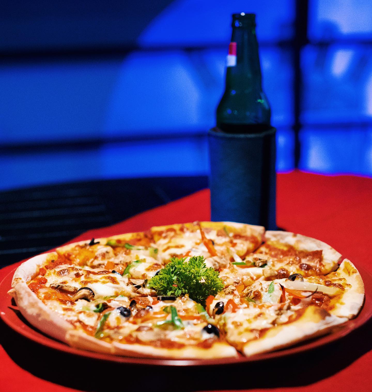 Fresh pizza and beer in the blue-lit bar